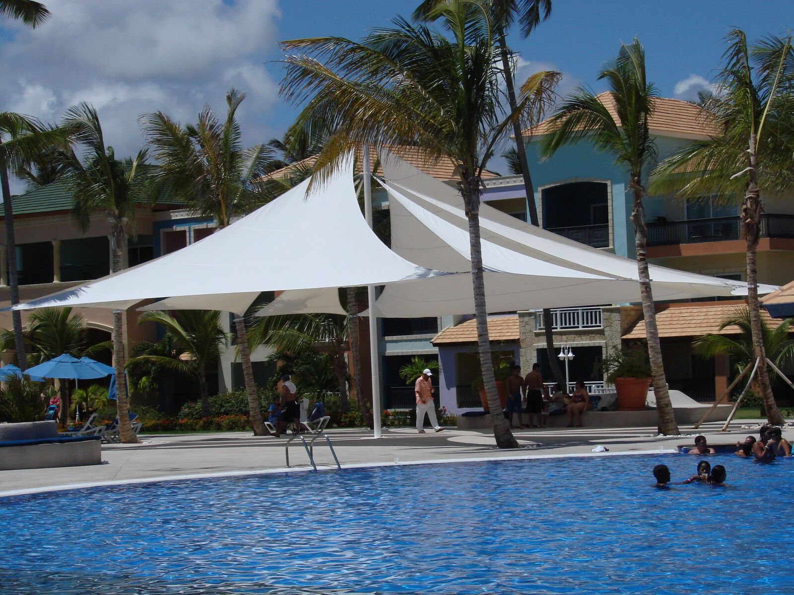 Velas tensadas junto a la piscina de un resort