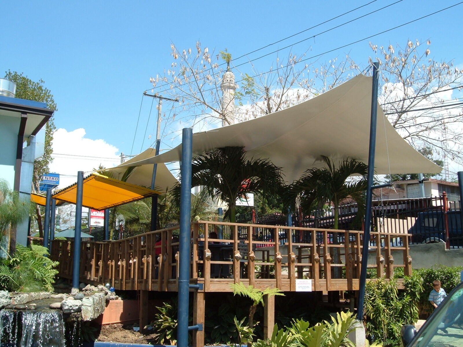 Velas tensadas sobre terraza de madera de restaurante